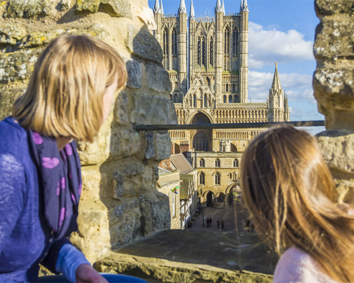 Two children on ϹӰԺ Castle wall look across at ϹӰԺ Cathedral