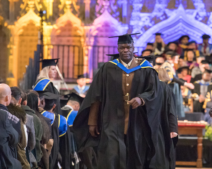 Student in gown and cap, walking down the aisle at a graduation ceremony in ϹӰԺ cathedral